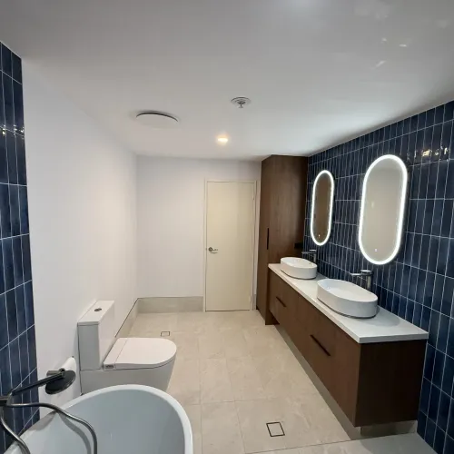 Bathroom renovation with a floating vanity and navy feature tiling
