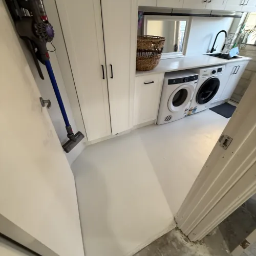Laundry renovation with custom cabinetry, washer and dryer, and a sink